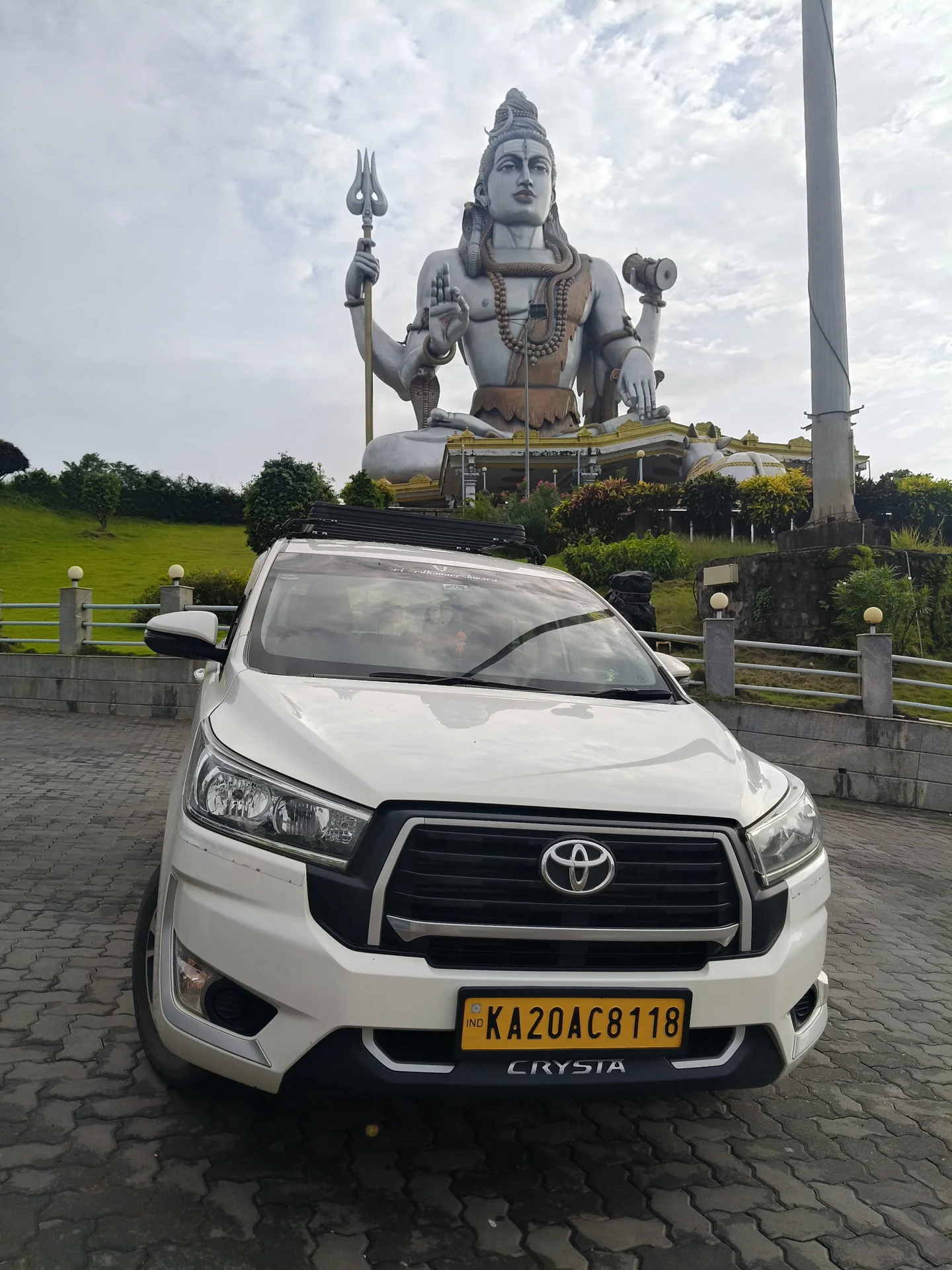 Atharv Cabs Innova Crysta framed directly beneath the 123-foot Lord Shiva statue at Murudeshwar