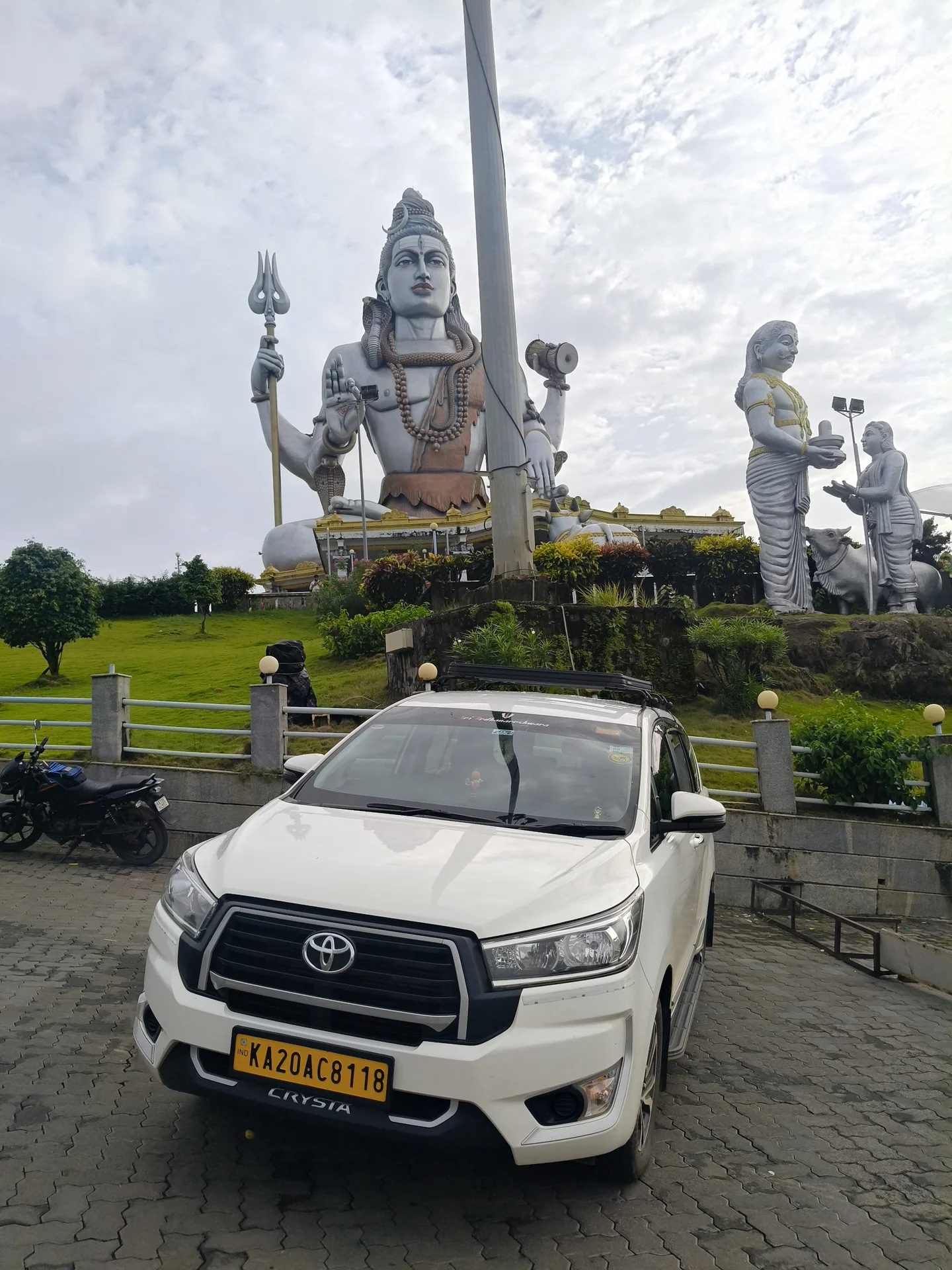 Atharv Cabs tourist taxi at Murudeshwar temple hill with Geeta Upadesh chariot in background